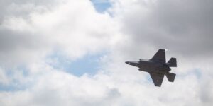 Jet plane flying in the sky under grey clouds